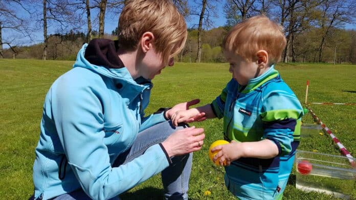 Mor og barn leger i naturen