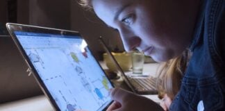 Synstab påvirker fremtidsmuligheder Kvinde har hovedet tæt på tabletskærm for at kunne læse op på sine studier