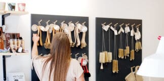 Få job-erfaring hos Blindes Arbejde En kvinde kigger på varerne i Blindes Arbejde, som er børster der hænger på væggen