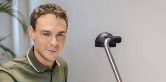 Følbar forandring for elever Ung blind mand sidder med hænderne på et taktilt landkort i Tactonome Reader