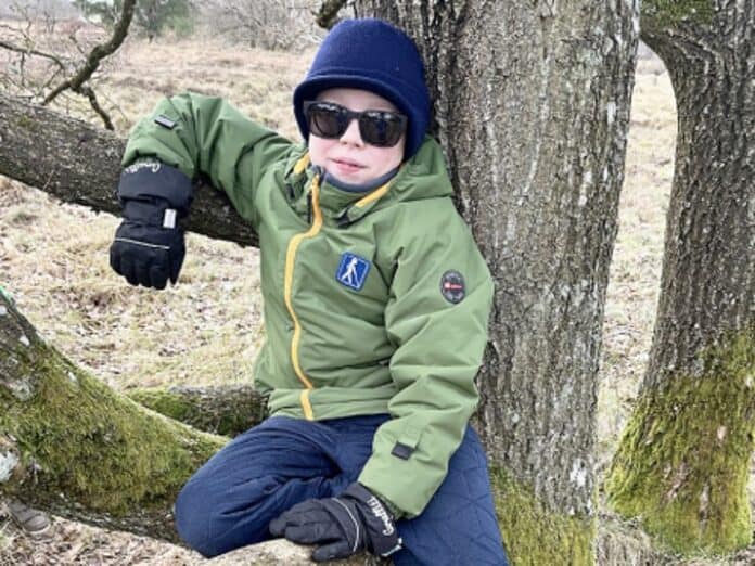 10årige Carl sidder med solbriller op ad et træ