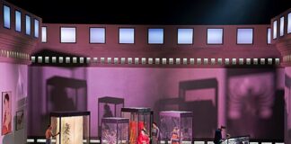 Lyt til kultur uden syn Scene fra Operaen Madam Butterfly på Det Kgl Teater, der er synstolket. Fire glasmontrer står i et lilla rum med rød belysning