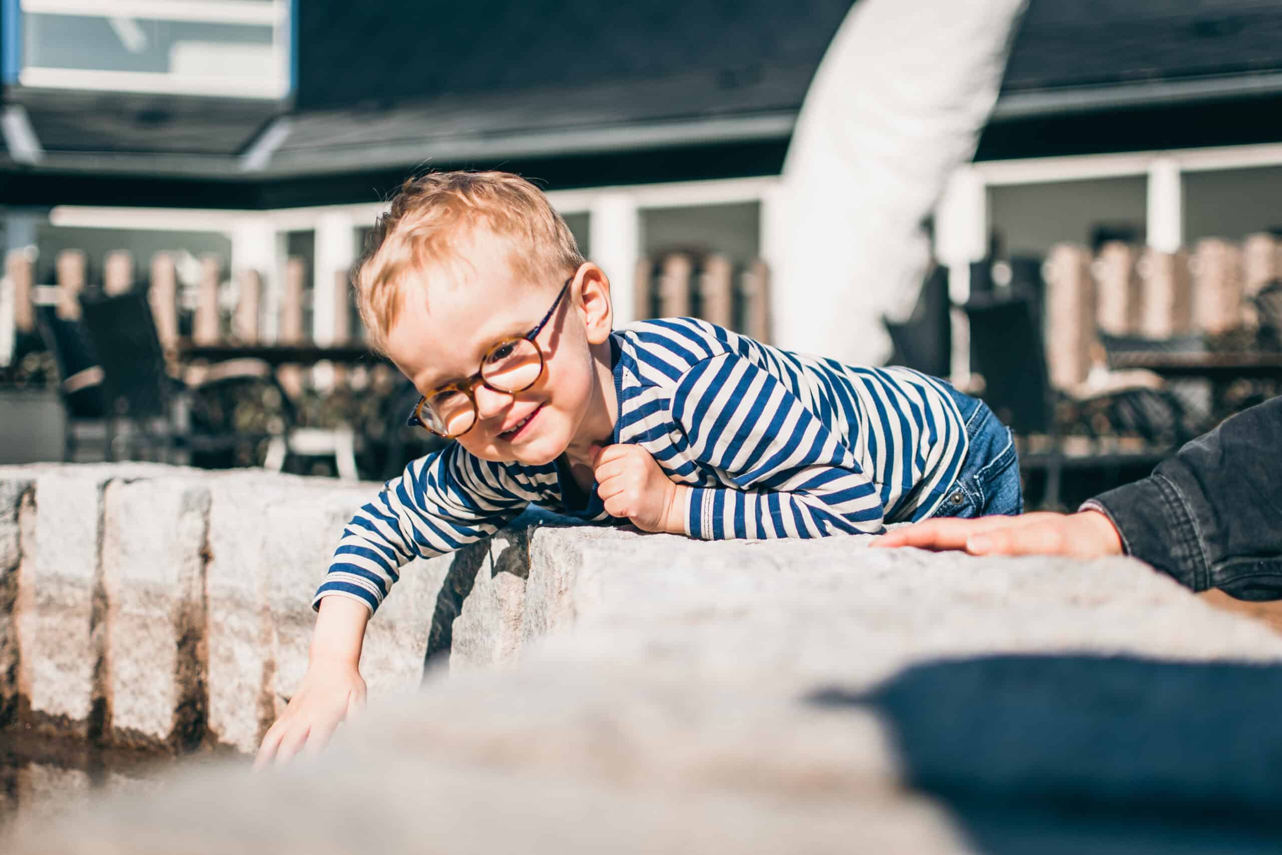 Den smilende Otto leger er vild med at føle. Her stikker han fingrene i vand.