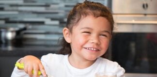 Opvækst med kan, vil og må selv Smilende pige smører selv en franskbrødsmad