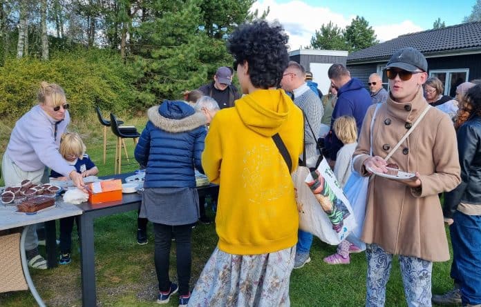 lalandia 1 En gruppe deltagere på årets Lalandiatur står udendørs foran kagebordet og snakker