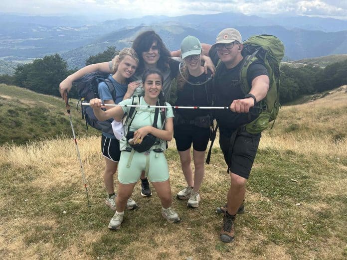 Selma i en flok af andre unge fra DBSU poserer foran bjerge på deres Camino-tur