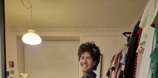 Legebarn som voksen Tor Pogan prøver en ternet, grå kjole på sit værelse ved siden af en fyldt garderobestang