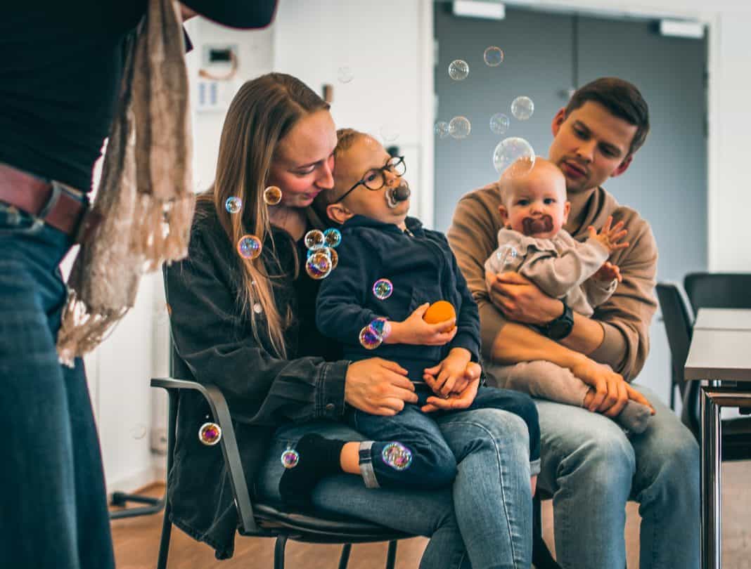 Karen og Mikkel sidder med deres børn, Otto og Ena, på skødet.