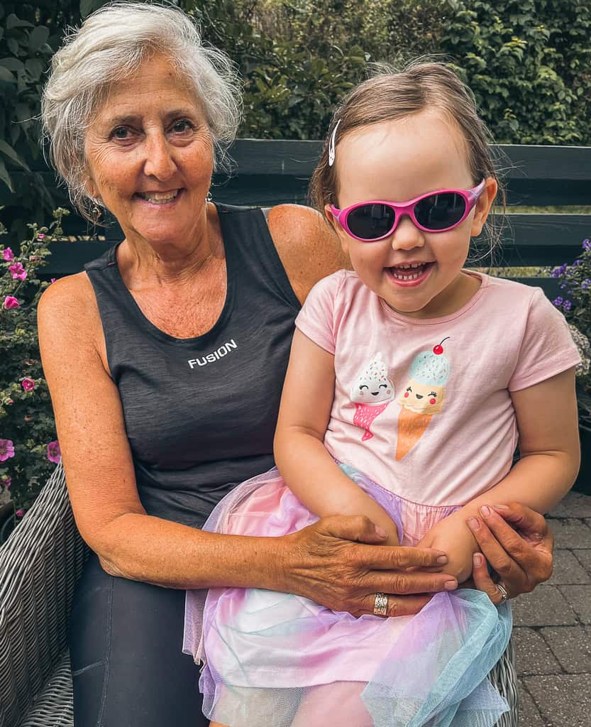 Her sidder Lykke, if&oslash;rt kjole med sk&oslash;rt og tegninger af is p&aring; brystet, p&aring; sk&oslash;det af mormor Tina. 