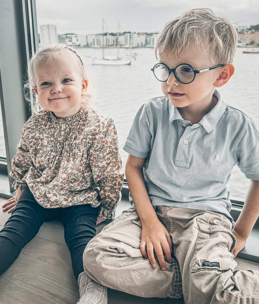 Ena og Otto sidder ved vinduet i deres oldefor&aelig;ldres lejlighed p&aring; havnen i Aalborg for at se Tall Ship Race.
